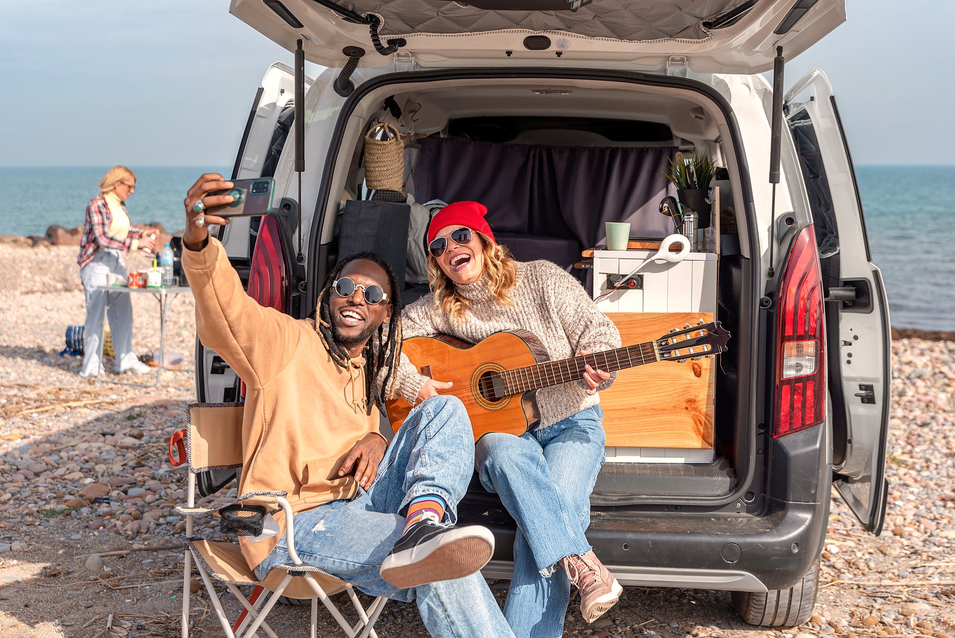 Two friends laughing together on a coastal road trip