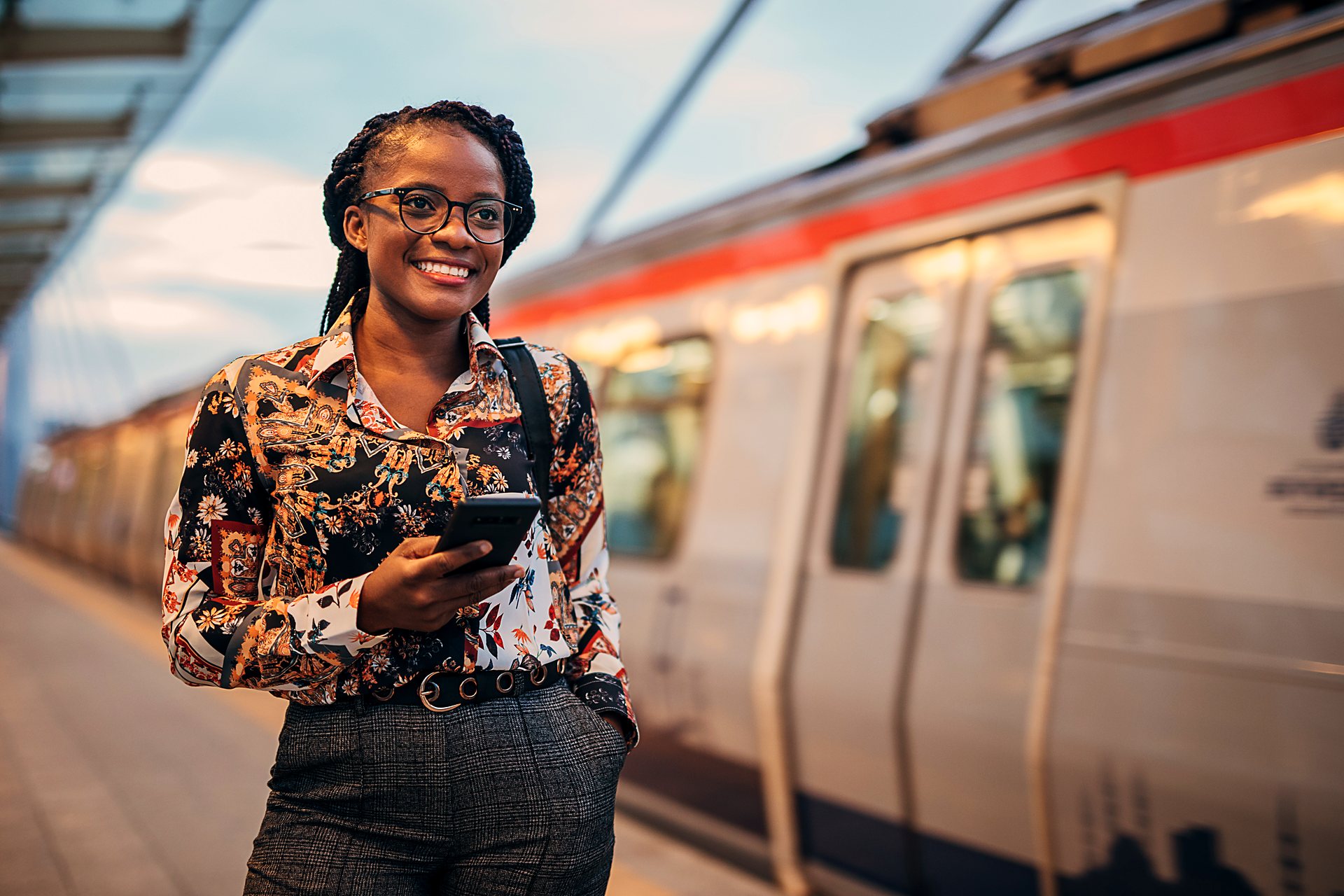 A business traveller with her phone on a train platform